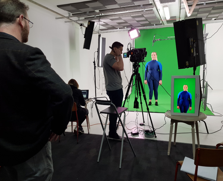 Film crew filming woman infront of green screen